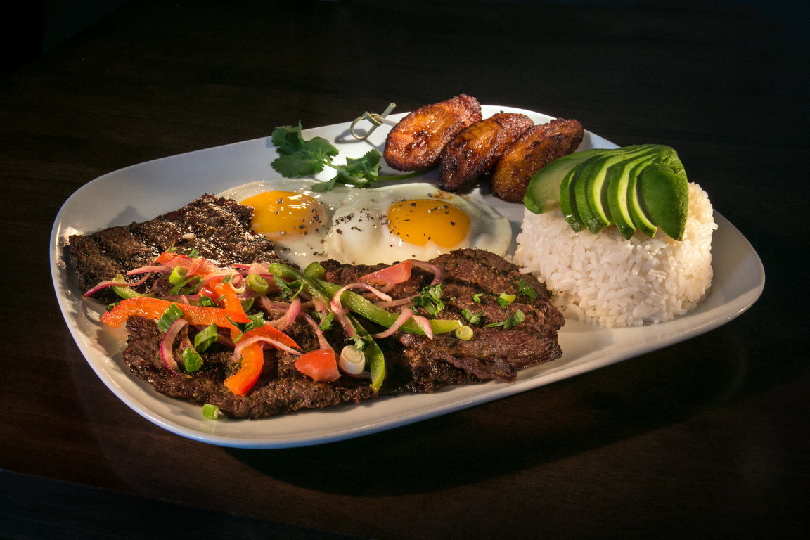 Churrasco: Grilled steak topped with onion, tomato, cilantro, and green & red peppers. Served with rice, two fried eggs, sweet plantain, and avocado. 